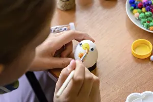 Close-up of hands of a child painting Easter eggs