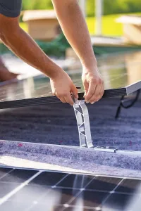 Close-up of hands installing a solar panel
