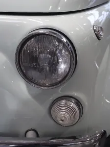 Close-up of a light blue vintage car with distinctive headlights and chrome