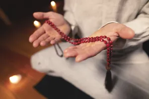 Close-up man in clothes for practice and meditation sits in a lotus pose
