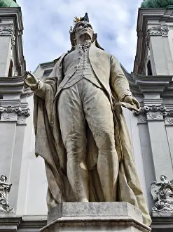 Close-up of a monumental statue of a man against a baroque background Wolfgang Amadeus Mozart Mariahilfer Church