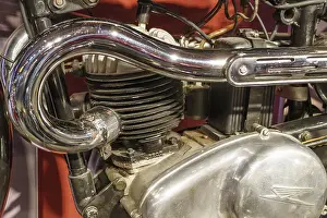 Close-up of a motorbike engine with chrome-plated exhaust pipe
