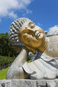 Close-up of a reclining Buddha statue radiating meditative calm against a clear blue sky