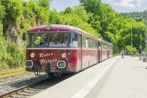 Close-up of a red train on a sunny platform