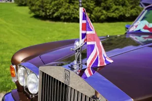 Close-up of a Rolls Royce with Union Jack flag and radiator grille in the foreground