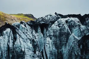 Close-up of rugged glacier peaks with patches of vegetation on top