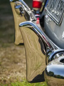 Close-up of a shiny chrome bumper of a classic car