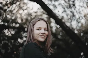 Close-up of smiling woman in a natural setting with soft focus