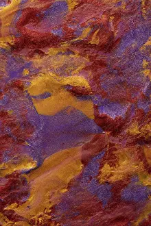 Close-up view of a vibrant, abstract metallic paint blend of red