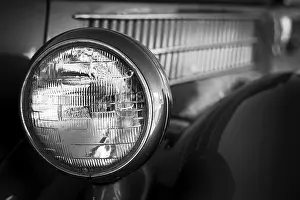 Close-up of a vintage car headlight and grille in black and white in St