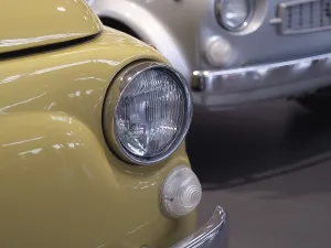 Close-up of a yellow vintage car with shiny chrome headlights