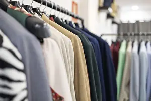 A close up view of assorted colorful clothes hanging on a rack