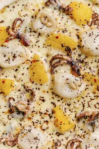 Close up view of a gourmet pizza topped with octopus