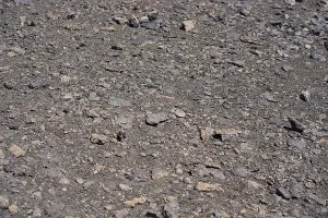 Close view of a volcanic ground covered with small rocks and rough texture