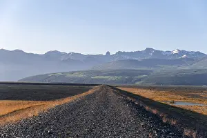 Closed gravel road, mountains and wide landscape behind