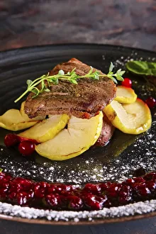 Closeup view of duck breast with apple and currant sauce