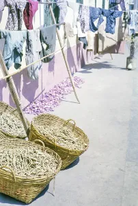 Clothes handing out to dry with baskets of what is thought to be clothes pegs