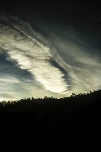 Cloud patterns swirl dramatically in the twilight sky