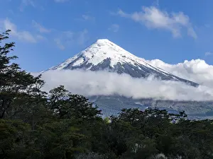 Clouds and forests on the snow-covered Osorno volcano