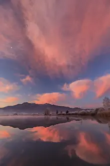 Cloudy mood, dawn, mountains reflected in lake