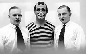 Clown between two men wearing lipstick