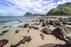 Coast and mountains, stones on the sandy beach of Uttakleiv