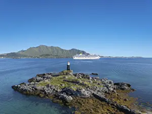 Coastal landscape with cruise ship in front of the distinctive Lofoten mountain range