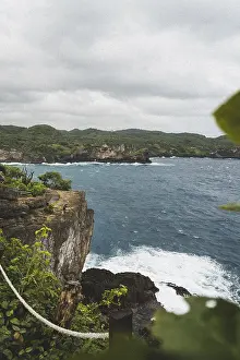 Coastal landscape with green cliffs and strong waves