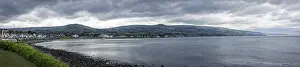 Coastal panorama with mountains in the background and cloudy sky