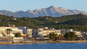 Coastal town at sunrise with a view of the sea and mountains in the background