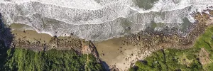 Coastline with beach, mountains and blue ocean with waves in Brazil