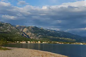 Coastline with mountains in the background under a cloudy sky