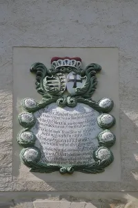 Coat of arms with text at the entrance to the castle and museum