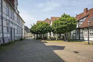 Category Cities DE Prints: Cobbled courtyard with traditional half-timbered houses and trees on a sunny day