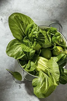A colander filled with fresh green vegetables