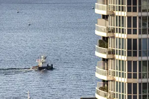 Framed Print : A color image of a boat on the water beside a modern apartment building in Toronto