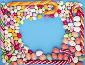 Colorful frame of multicolored candies on a blue background