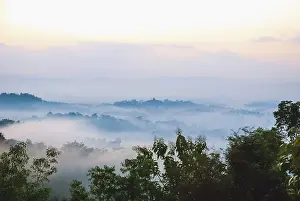 Colorful sunrise over jungle with Merapi volcano behind and Borobudur temple