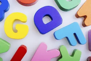 Colorful wooden letters scattered on a white background