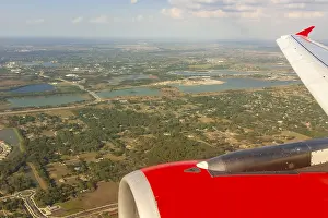 A colour landscape image looking out through airplane window showing land