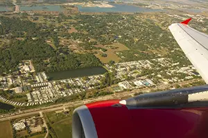 A colour landscape image looking out through airplane window showing land