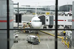 A colour landscape image showing a passenger jet at the gate at an airport