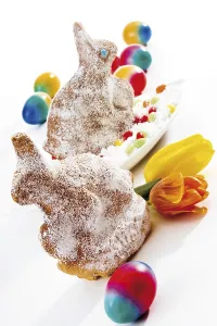 Coloured eggs and Easter bunnies made of sponge cake and covered in icing sugar