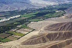 Colourful agricultural plots contrasting with bare desert mountains