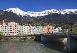 Colourful buildings along the Inn river with snow-covered Nordkette in the background