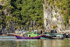 Colourful fishing boats lean against each other in the water