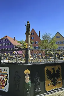 Colourful historic buildings on the market square with fountain and statue under clear sky