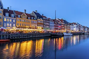 Colourful houses, restaurants and historic ships on the Nyhavn canal and harbour at dusk