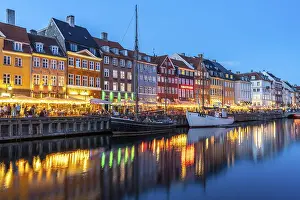 Colourful houses, restaurants and historic ships on the Nyhavn canal and harbour at dusk