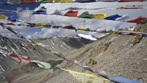 Colourful prayer flags flutter against a high-mountain backdrop